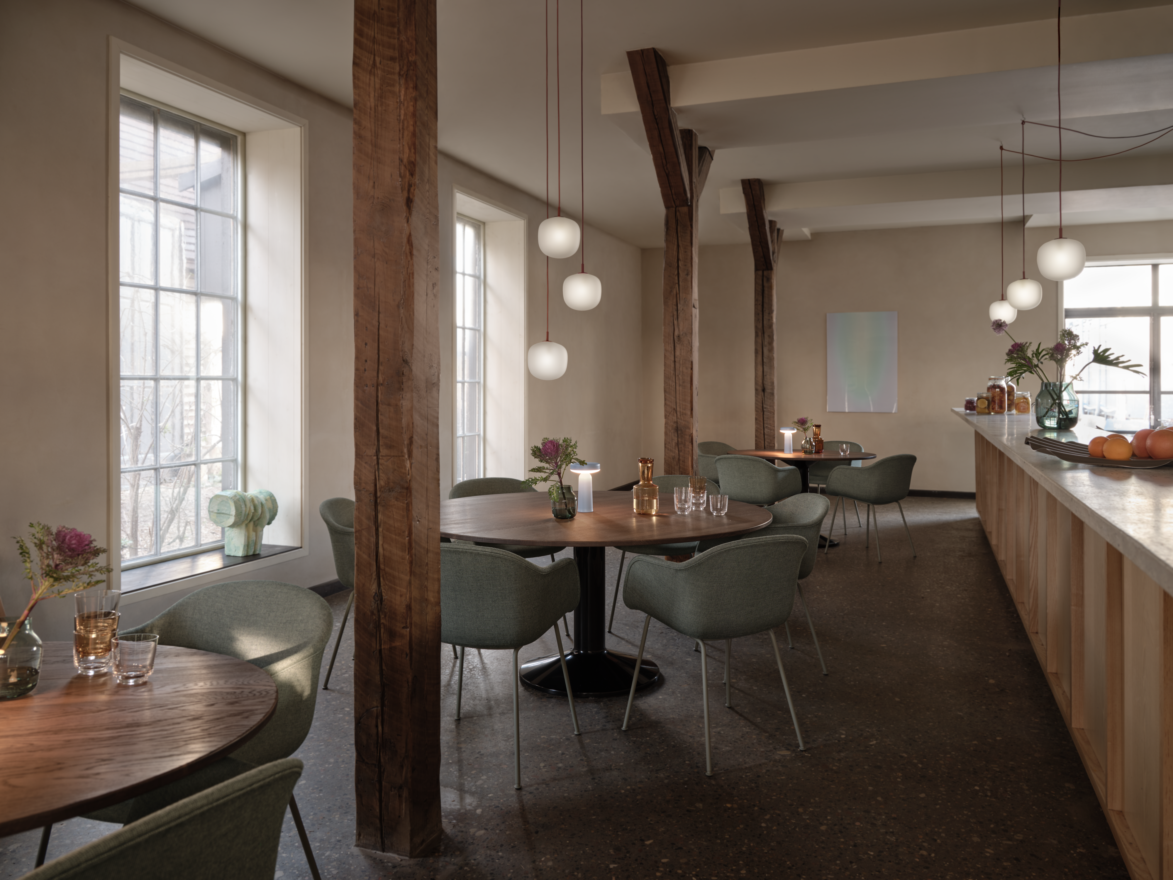 Midst Table Ø160 cm in Dark Oiled Oak/Black - Fiber Armchair Tube Base Sabi 921/Dusty Green - Rime Pendant Lamp Ø18 cm in Deep Red - Ease Portable Lamp in Light Blue - Silent Vase Ø11 & Ø20 cm in Dark Green - Raise Carafe in Burnt Orange - Raise Glasses in Clear - Wave Tray