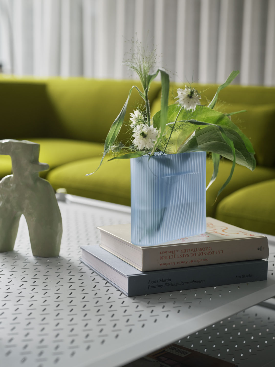 A Muuto living space featuring a grey Flow coffee table in grey with a Ridge vase 16 cm in light blue frosted glass. The table is complemented by the Connect Soft sofa with Vidar 956 upholstery. The arrangement of these modern pieces enhances the room with a chic and cohesive look.