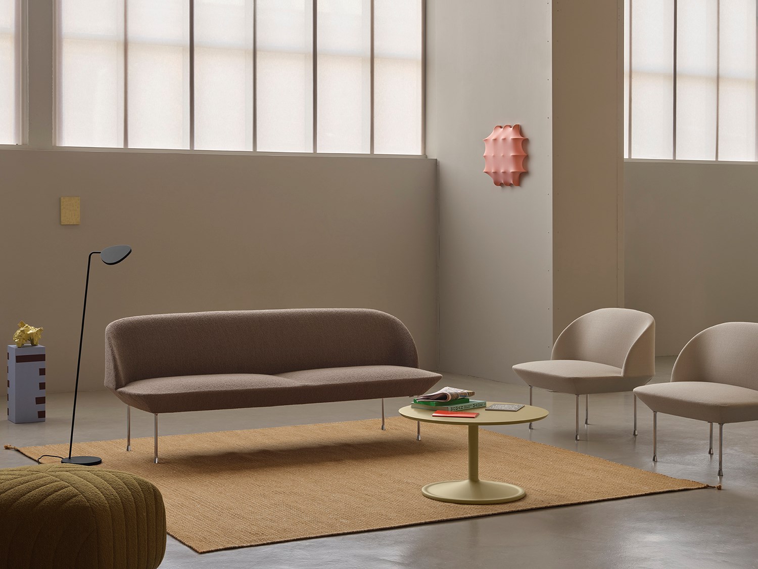 Oslo 3-seater sofa in light brown-grey, flanked by two light grey lounge chairs and a minimalistic black floor lamp. A simple round coffee table sits at the center of the room. Oslo 3-seater sofa in light brown-grey, flanked by two light grey lounge chairs and a minimalistic black floor lamp. A simple round coffee table sits at the center of the room.
