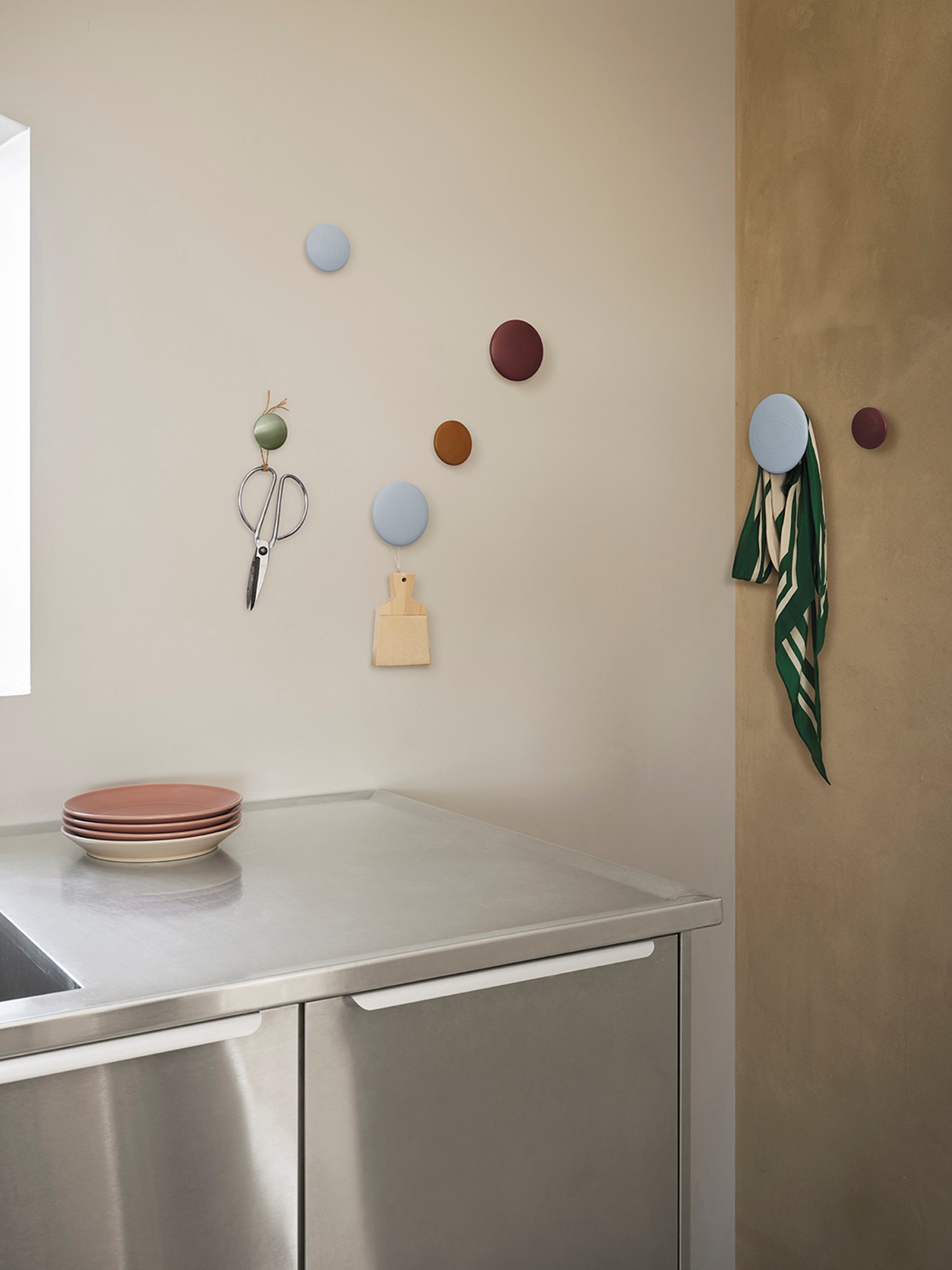 Colorful Dots in light blu, burgundy and metal are  hanging over a metal kitchen table.  Colorful Dots in light blu, burgundy and metal are  hanging over a metal kitchen table.